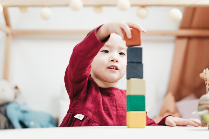 A child plays with stacking blocks