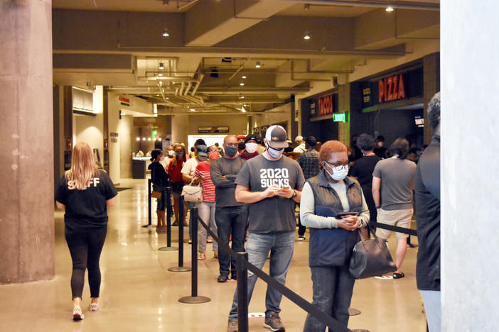 Hundreds of voters wait in line at State Farm Arena in Atlanta during the first day of in-person early voting Oct. 12, 2020.