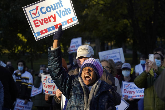 Demonstrator Karen Louise Gonsalves, center, displays a placard, Wednesday, Nov. 4, 2020, during a protest as ballots continue to be counted in some battleground states for the general election.