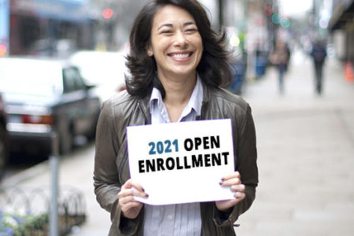 Woman holding open enrollment sign