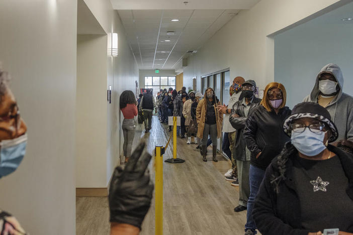 The line for early voting at the Lucas Senior Center in Macon stretched out the front door on the first day of early voting Monday.