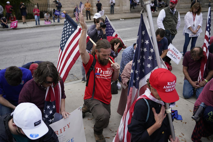 Supporters of President Donald Trump pray near the state capitol, Saturday, Nov. 7, 2020 in Atlanta.