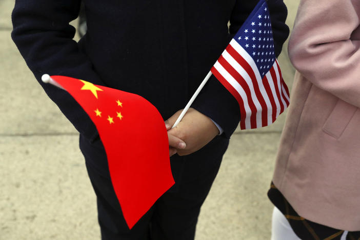 People hold Chinese and American flags as they wait for President Donald Trump and Chinese President Xi Jinping to participate in a welcome ceremony at the Great Hall of the People, Thursday, Nov. 9, 2017, in Beijing, China. (AP Photo/Andrew Harnik)