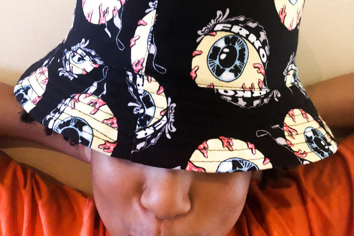 Elijah Gomez wearing a black bucket hat with an eyeball design.