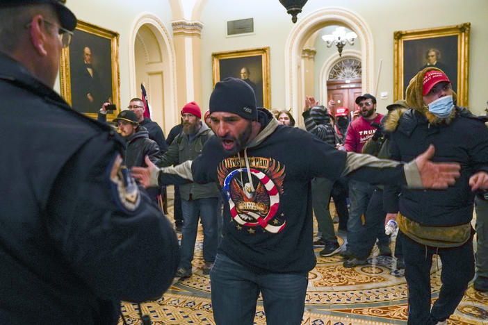 Trump supporters gesture to U.S. Capitol Police in the hallway outside of the Senate chamber at the Capitol in Washington, Wednesday, Jan. 6, 2021. 