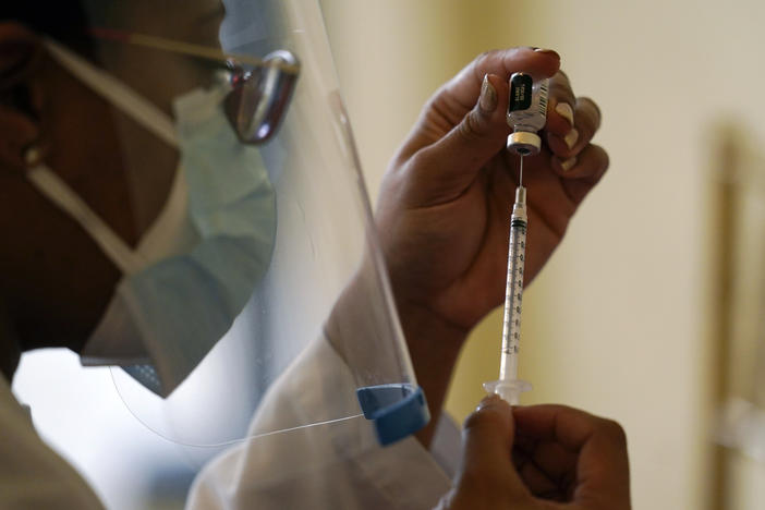 A Walgreens pharmacist prepares a syringe with the Pfizer-BioNTech COVID-19 vaccine for residents and staff at the The Palace assisted living facility in Coral Gables, Fla.