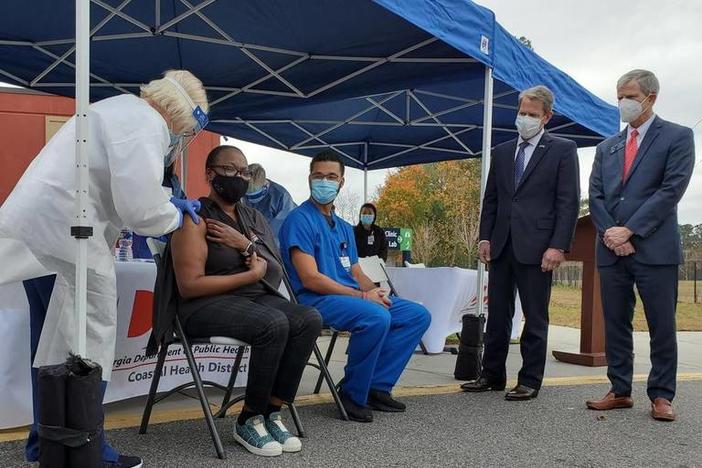 Tammi Brown, Chatham County Health Department Nurse Manager, was among the first in Georgia to receive the vaccine against COVID-19, as Memorial University Medical Center emergency room nurse David Wilson awaits another dose and Gov. Brian Kemp and State Sen. Ben Watson look on.