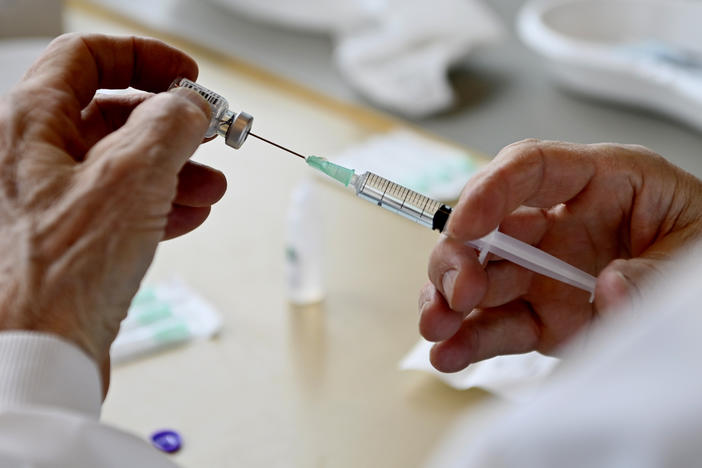 A healthcare worker prepares to administer the Pfizer-BioNTech vaccine, during the start of the COVID-19 vaccination campaign for those in higher risk categories, at a vaccine center in Overijse, Belgium.