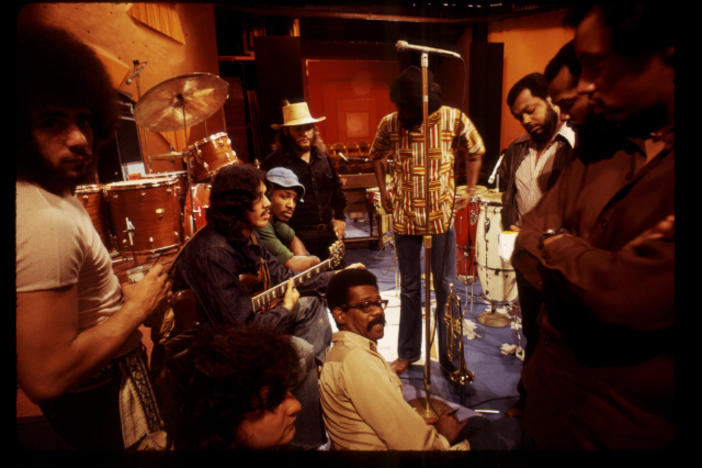 Men standing and seated with musical instruments.