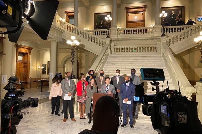 A group of lawmakers hold a press conference in the General Assembly.