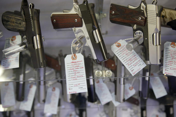 In this Nov. 15, 2014 file photo, handguns sit in a glass display case in Bridgeton, Mo. The FBI processed a record number of firearms background checks on Black Friday, the agency said Tuesday.