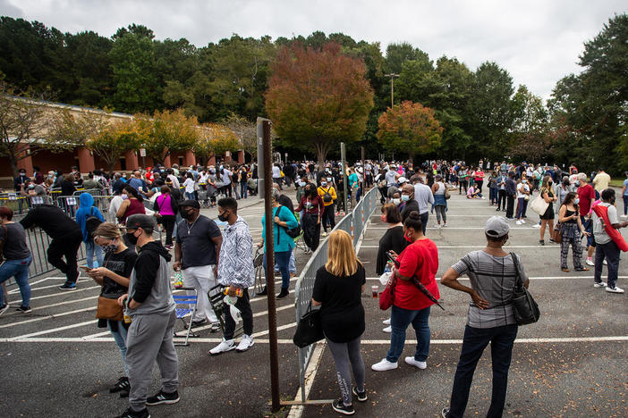 Hundreds of people wait in line for early voting on Monday, Oct. 12, 2020, in Marietta, Georgia. Eager voters have waited six hours or more in the former Republican stronghold of Cobb County, and lines have wrapped around buildings in solidly Democratic DeKalb County.