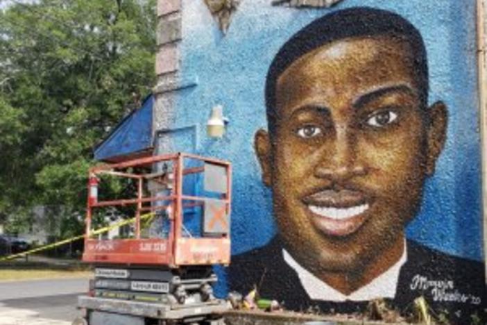 A mural of Ahmaud Arbery graces a wall near the Glynn County Courthouse where three men were indicted for murder in his killing.