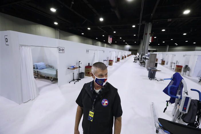 Mark Sexton, deputy director of the Georgia Emergency Management and Homeland Security Agency, tours the alternative hospital bed capacity facility the state of Georgia is re-activating at the Georgia World Congress Center, Tuesday, Dec. 29, 2020, in Atlanta, amid the coronavirus pandemic.