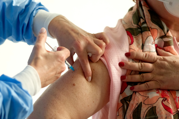 A women receives a vaccine shot.