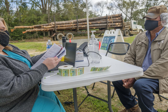 Peanut farmer Gerue Reliford, Jr. gets checked into the mobile vaccine clinic parked in Preston, Ga. recently. Reliford said he'd been anxious to get vaccinated but had to wait for the age limit to drop to 55+. Even so, it was hard to take time from harrowing peanut fields in the spring to make an appointment. The mobile clinic helped. "I just jumped in my truck and came over," Reliford said. 