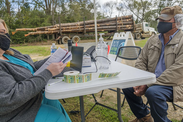 Peanut farmer Gerue Reliford, Jr. gets checked into the mobile vaccine clinic parked in Preston, Ga. recently. Reliford said he'd been anxious to get vaccinated but had to wait for the age limit to drop to 55+. Even so, it was hard to take time from harrowing peanut fields in the spring to make an appointment. The mobile clinic helped. "I just jumped in my truck and came over," Reliford said. 