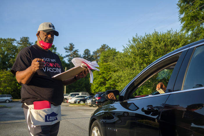 Reverend James Baker tries to a convince someone he checked into into an energy assistance program to also be vaccinated at St. Paul AME in Macon, Tuesday, April 27. Baker said he hears a lot of people say God will keep them safe from COVID-19. He says some of those who have told him that are dead. 