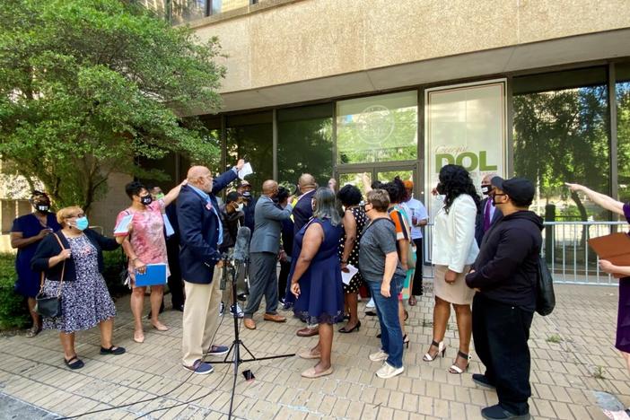 State lawmakers and worker advocates shout, “Open up these doors!” during a protest outside the Georgia Department of Labor office in Atlanta on May 19, 2021. 