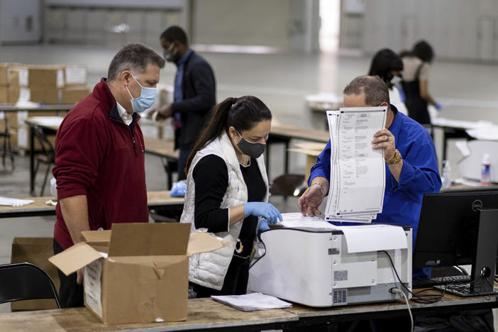 Workers scan ballots as the Fulton County presidential recount gets under way Wednesday morning, Nov. 25, 2020 at the Georgia World Congress Center in Atlanta. 