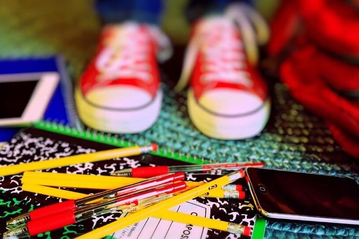 Child standing on school supplies