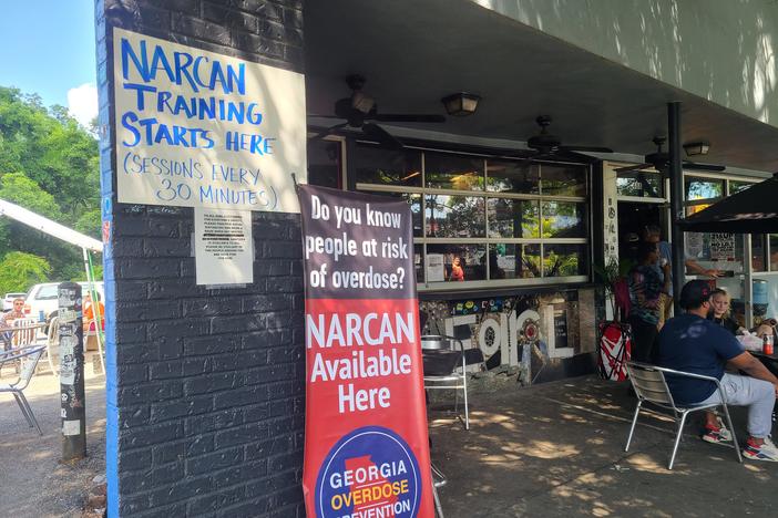 Signs outside the EARL direct people toward Narcan training inside the bar.