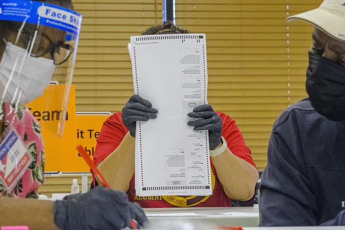A man inspects a ballot.