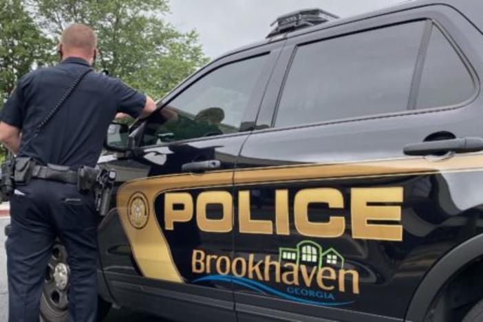 Police officer standing next to car