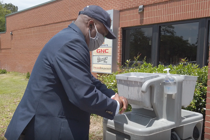 Savannah Mayor Van Johnson wearing a mask and washing his hands