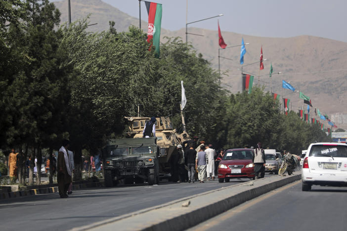 Taliban fighters stand guard on the road leading to the Hamid Karzai International Airport, in Kabul, Afghanistan, Monday, Aug. 16, 2021.