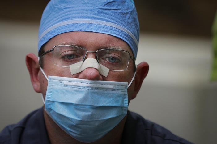 Chaplain Will Runyon holds back tears as he speaks of the hardships and death amid the COVID-19 coronavirus outbreak outside of Phoebe Putney Memorial Hospital in Albany, Ga., on Monday, April 20, 2020. The hospital has once again be inundated with COVID-19 cases since the onset of the delta variant, breaking last year's records.