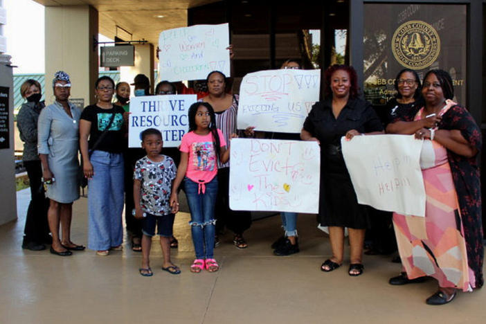 Cobb County residents protest with signs outside of the Cobb County Board of Commissioners meeting on June 22, 2021.