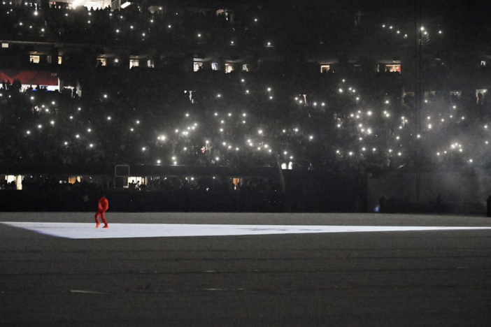 Hip-hop musician Kanye West is dwarfed by a sold-out Mercedes-Benz Stadium in Atlanta during one of two August 2021 listening party events for his upcoming album "Donda."  