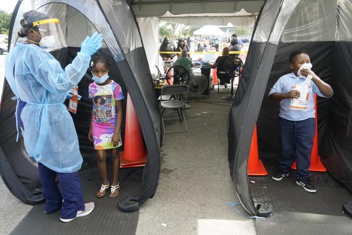 Wenderson Cerisene, 7, right, and his sister Dorah, 9, wait to get tested for COVID-19 in August 2021 in Florida.