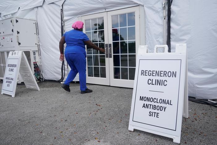 A nurse walks into a tent clinic