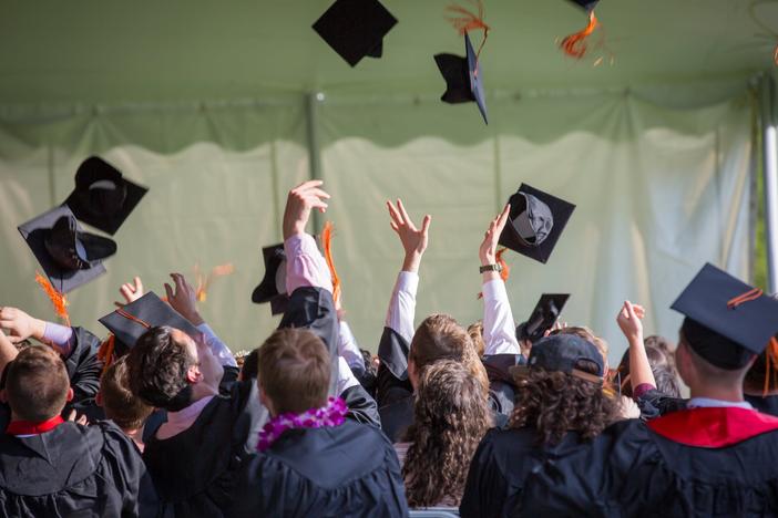Graduates tossing hats into air