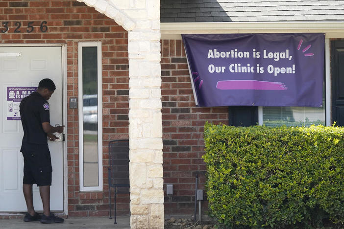 A security guard opens the door to the Whole Women's Health Clinic in Fort Worth, Texas, Wednesday, Sept. 1, 2021.