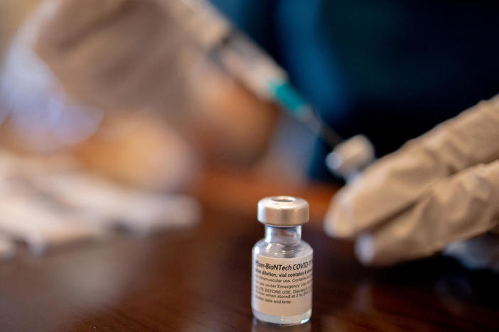 A health care worker prepares third doses of Pfizer-BioNTech COVID-19 vaccines for a senior living facility in Worcester, Pa., in late August.