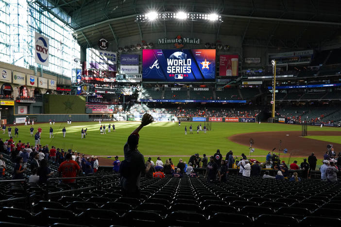 A fan waits for a fly ball during batting practice before Game 2 of baseball's World Series between the Houston Astros and the Atlanta Braves Wednesday, Oct. 27, 2021, in Houston.