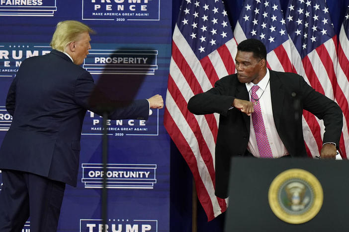 In this Sept. 25, 2020, file photo, President Donald Trump elbow bumps with Herschel Walker during a campaign rally in Atlanta.