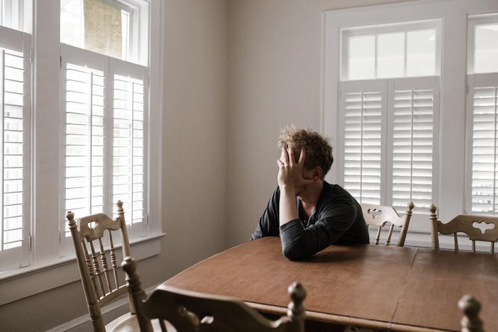 Sad person sitting at table