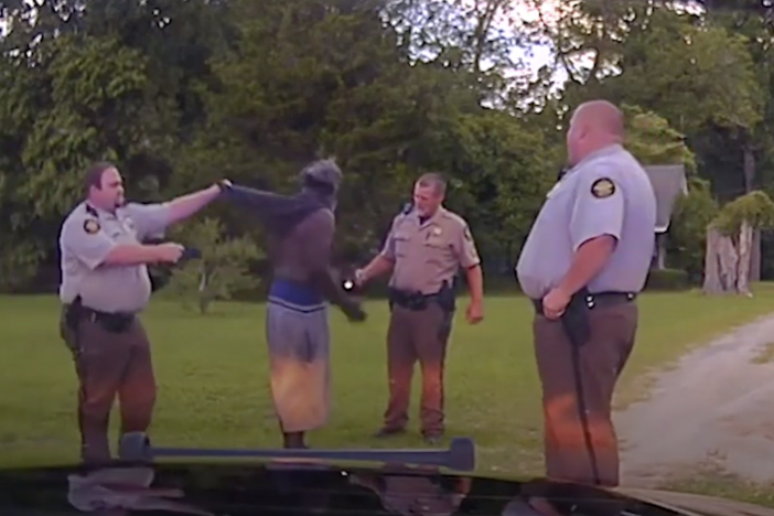 Rhett Scott, left, lifts Eurie Martin's shirt in order to get skin only taser contact as Henry Lee Copeland, center right, and Michael Howell talk to Martin during the 2017 encounter where Martin died. 