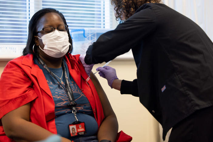 Nekesha Murphy (left) gets her COVID-19 vaccine from RN Ginn Holder at the University Health Center. 