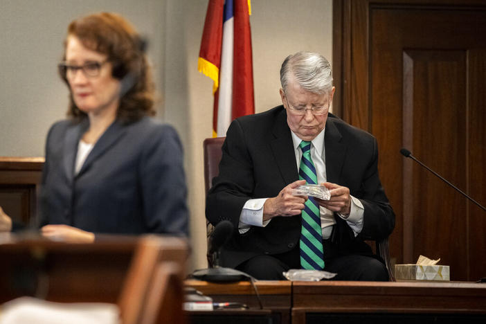 Dr. Edmund R. Donoghue, right, the Georgia Bureau of Investigation Forensic Pathology Specialist, examines shotgun pellets entered into evidence during the trial of Greg McMichael and his son, Travis McMichael, and a neighbor, William "Roddie" Bryan in the Glynn County Courthouse, Tuesday, Nov. 16, 2021, in Brunswick, Ga.
