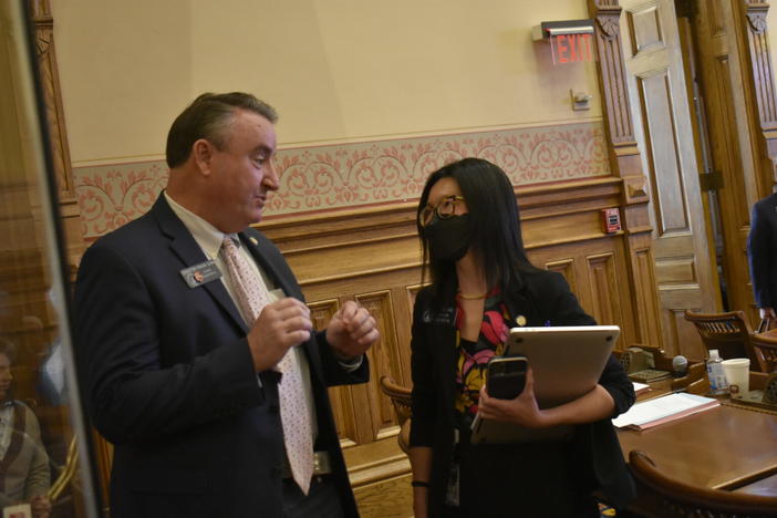  From left, Sens. Frank Ginn, a Republican from Danielsville, and Michelle Au, a Democrat from Johns Creek, talk on the Senate floor. Au is the only senator in a competitive district under the redistricting plan awaiting Gov. Kemp’s signature. 