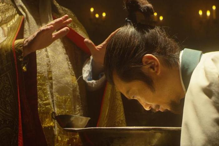 A Japanese man participates in a Catholic ceremony.