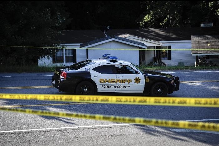 Law enforcement guard outside the crime scene in which five people were shot and 4 killed at a home, Wednesday, July 22, 2015, in Suwanee, Ga. At least four people, including the gunman and two children under the age of 10, were killed in a domestic-related shooting Wednesday inside a home in suburban Atlanta, officials said. (AP Photo/John Amis)