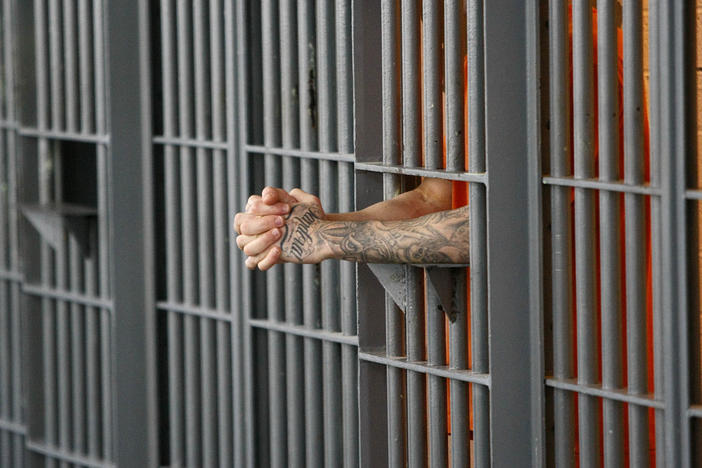 FILE - In this Nov. 14, 2009 file photo, an inmate stands at his cell door at the maximum security facility at the Arizona State Prison in Florence, Ariz. A new Arizona law that charges visitors to state prisons a one-time $25 fee is being challenged as unconstitutional.