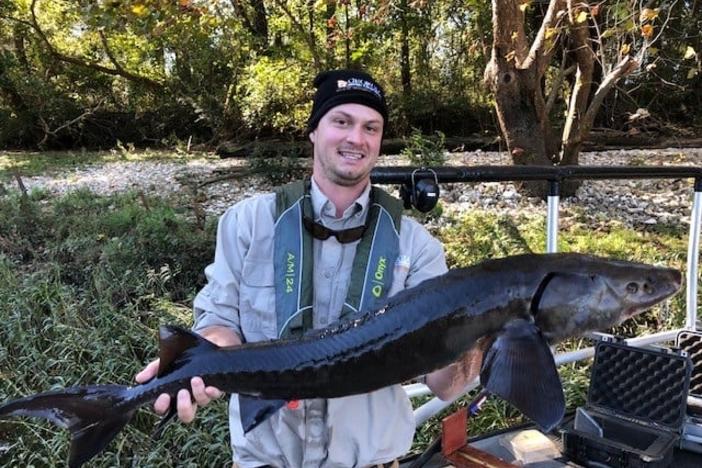 Fisherman holding Sturgeon