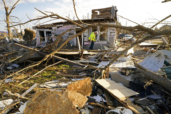 An Atmos Energy employee checks gas meters after the gas mains were shut off, in the aftermath of tornadoes that tore through the region, in Mayfield, Ky., Tuesday, Dec. 14, 2021. (AP Photo/Gerald Herbert)